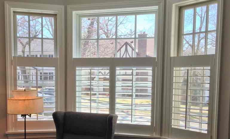 Bottom half plantation shutters in family room bay window.